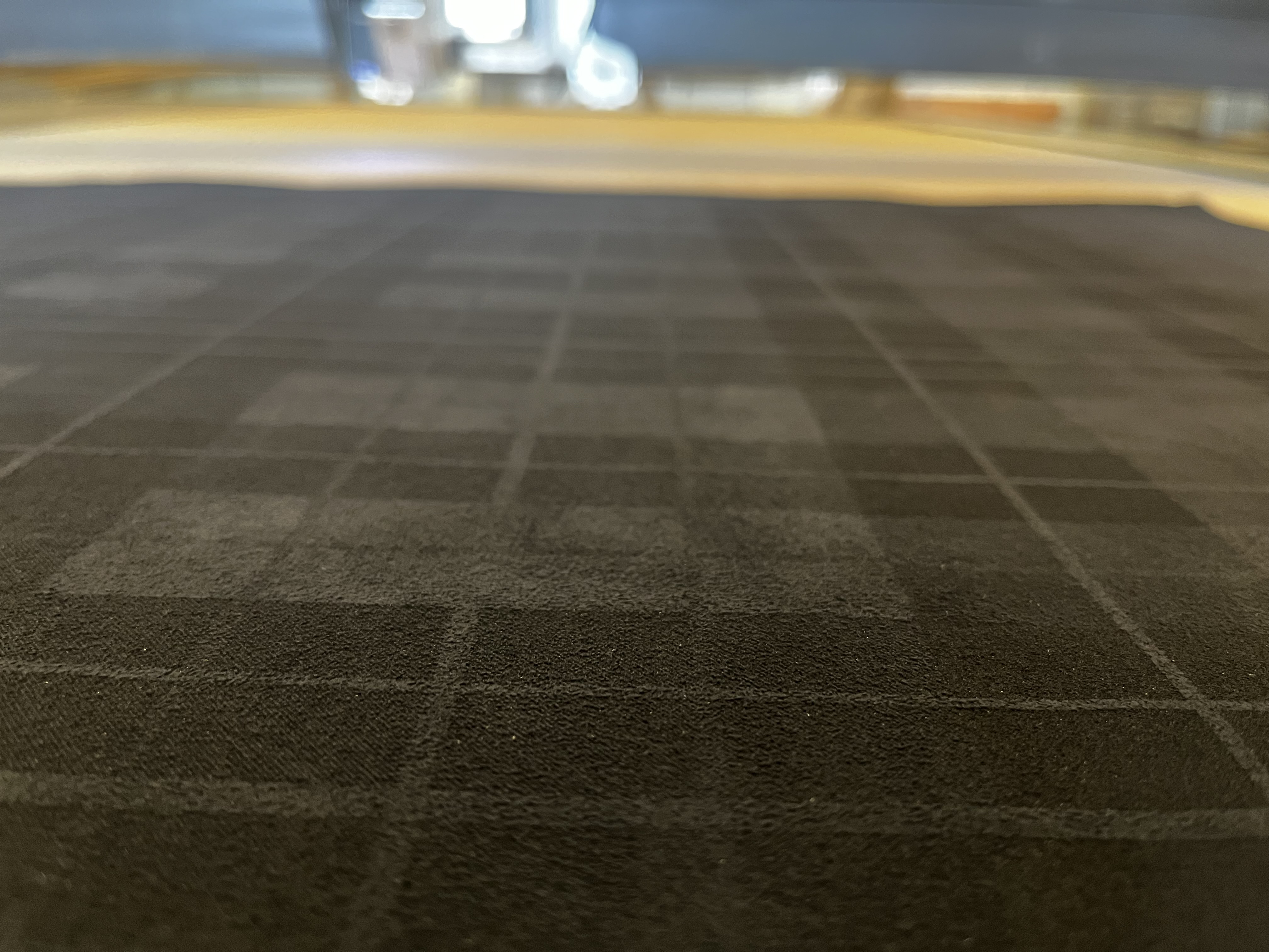 Close-up of a repeating pattern on a dark textured sheet